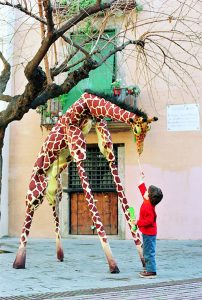 Două girafe și puiul lor se plimbă pe străzile orașului pe un fond sonor care recreează auditiv sunetele savanei